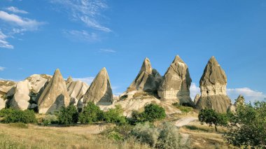 Türkiye 'nin Kapadokya şehrinin gerçeküstü ve dünya dışı manzarası, berrak mavi gökyüzünün altındaki ünlü baca kaya oluşumlarıyla.