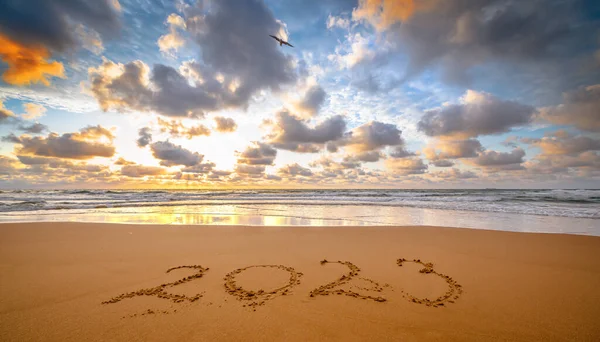2023 numara gün doğumunda deniz kıyısındaki kumlara yazılmış. Yaklaşan yeni yıl ve zaman kavramı.