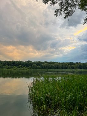 Sakin sular, doğanın güzelliğinin ahenkli bir karışımını yaratan canlı gökyüzünü yansıtır. Huzurlu sahne bir sükunet ve sükunet hissi yayar.