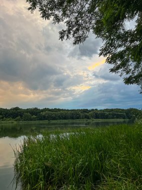 Sakin sular, doğanın güzelliğinin ahenkli bir karışımını yaratan canlı gökyüzünü yansıtır. Huzurlu sahne bir sükunet ve sükunet hissi yayar.