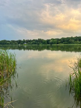 Sakin sular, doğanın güzelliğinin ahenkli bir karışımını yaratan canlı gökyüzünü yansıtır. Huzurlu sahne bir sükunet ve sükunet hissi yayar.
