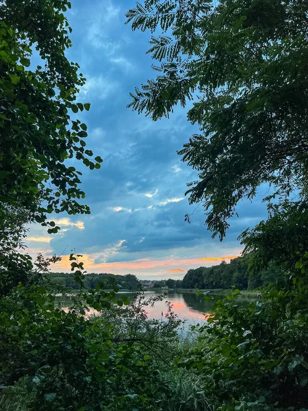 Sakin sular, doğanın güzelliğinin ahenkli bir karışımını yaratan canlı gökyüzünü yansıtır. Huzurlu sahne bir sükunet ve sükunet hissi yayar.