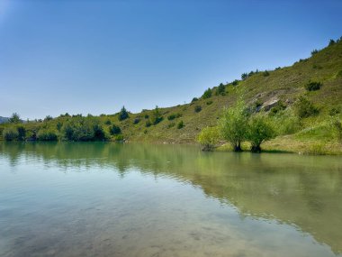 Karpat dağlarında, güneşli havada kayaların arasındaki göl manzaralı harika bir manzara.
