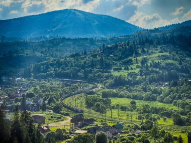 Güneşli bir günde bulutlarla kaplı Karpat Dağlarının Manzarası