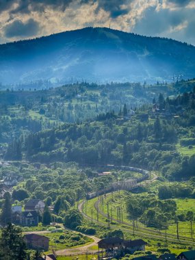 Güneşli bir günde bulutlarla kaplı Karpat Dağlarının Manzarası