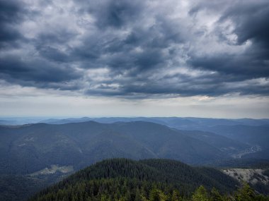 Kasvetli bir Karpatya manzarası, görkemli ve zamansız bulutlu gökyüzü altında.