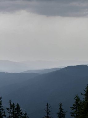Kasvetli bir Karpatya manzarası, görkemli ve zamansız bulutlu gökyüzü altında.