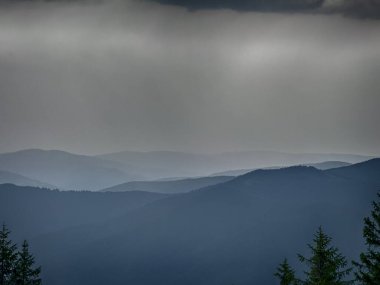 Kasvetli bir Karpatya manzarası, görkemli ve zamansız bulutlu gökyüzü altında.