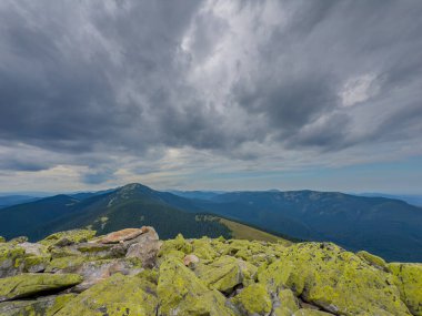 Kasvetli bir Karpatya manzarası, görkemli ve zamansız bulutlu gökyüzü altında.