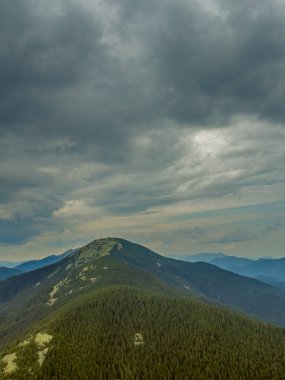 Kasvetli bir Karpatya manzarası, görkemli ve zamansız bulutlu gökyüzü altında.