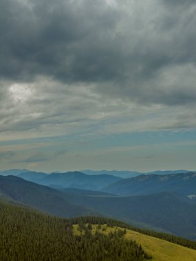 Kasvetli bir Karpatya manzarası, görkemli ve zamansız bulutlu gökyüzü altında.