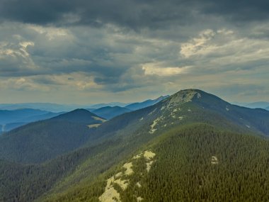 Kasvetli bir Karpatya manzarası, görkemli ve zamansız bulutlu gökyüzü altında.