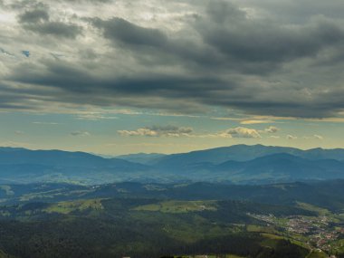Kasvetli bir Karpatya manzarası, görkemli ve zamansız bulutlu gökyüzü altında.