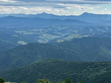 Güneşli Karpat tepeleri: yeşil vadiler ve kristal berrak gökyüzü.