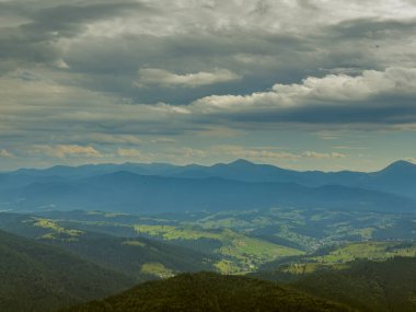 Güneşli Karpat tepeleri: yeşil vadiler ve kristal berrak gökyüzü.