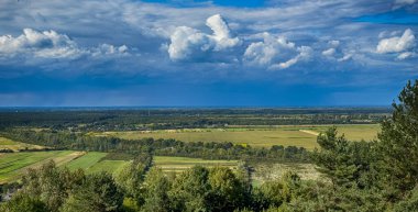 Dramatik bulutlu gökyüzünün altındaki köyün tepe manzarası. Yağmurdan önce kırsal köy manzarası