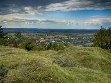 Dramatik bulutlu gökyüzünün altındaki köyün tepe manzarası. Yağmurdan önce kırsal köy manzarası