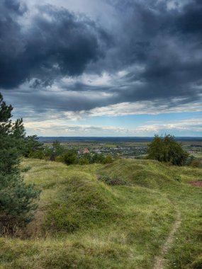 Dramatik bulutlu gökyüzünün altındaki köyün tepe manzarası. Yağmurdan önce kırsal köy manzarası
