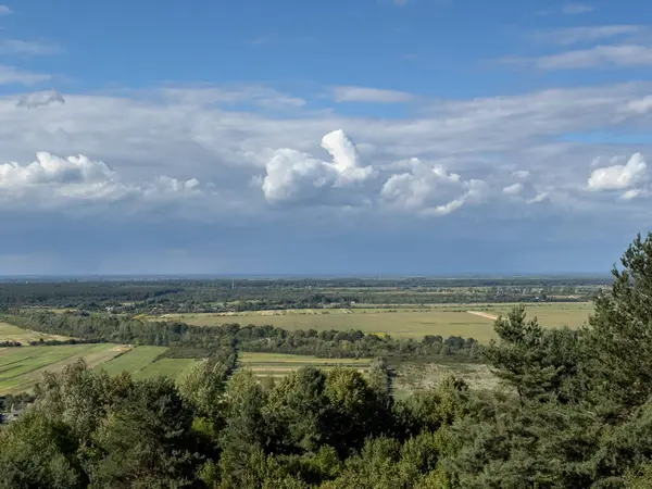 Dramatik bulutlu gökyüzünün altındaki köyün tepe manzarası. Yağmurdan önce kırsal köy manzarası