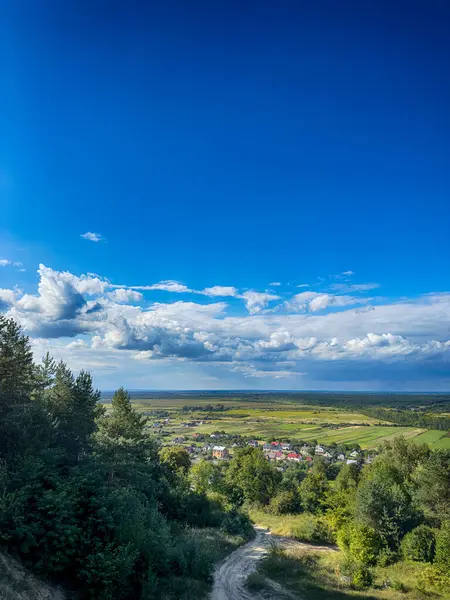 Dramatik bulutlu gökyüzünün altındaki köyün tepe manzarası. Yağmurdan önce kırsal köy manzarası