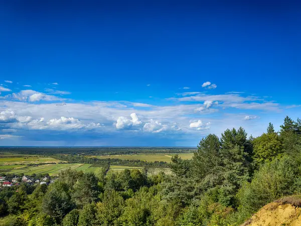 Dramatik bulutlu gökyüzünün altındaki köyün tepe manzarası. Yağmurdan önce kırsal köy manzarası
