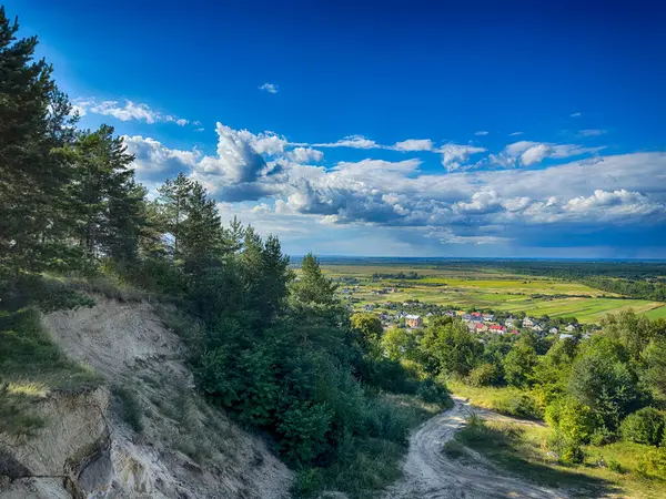Dramatik bulutlu gökyüzünün altındaki köyün tepe manzarası. Yağmurdan önce kırsal köy manzarası