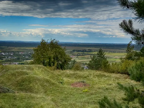 Dramatik bulutlu gökyüzünün altındaki köyün tepe manzarası. Yağmurdan önce kırsal köy manzarası