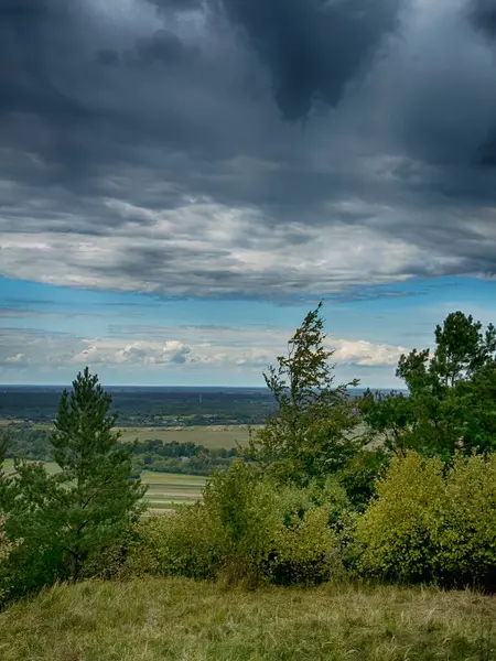 Dramatik bulutlu gökyüzünün altındaki köyün tepe manzarası. Yağmurdan önce kırsal köy manzarası