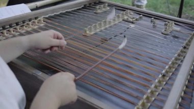 İnsan geleneksel cimbalon müzik enstrümanı çalıyor.