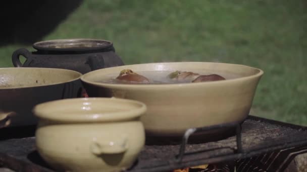 户外用木柴和陶瓷器皿烹调食品 — 图库视频影像