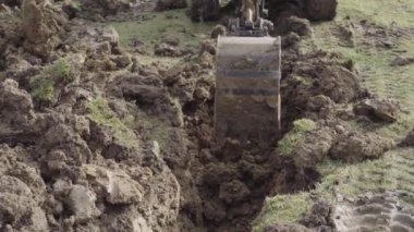 Küçük kazıcı toprağı yüklüyor.