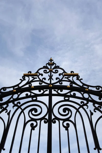 Wrought iron gate and blue sky on background