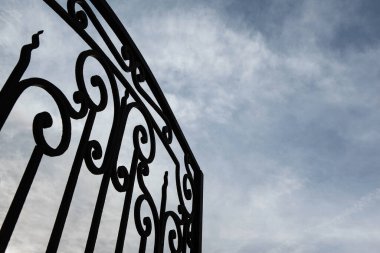 Ferforje kapı ve arka plan üzerinde bulutlu gökyüzü