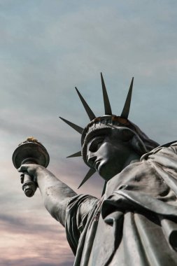 Weathered Statue of Liberty and colorful sky on background clipart