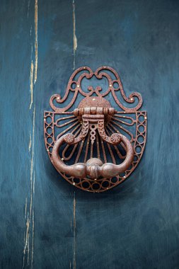 Eski bronz tokmak mavi ahşap bir kapıda