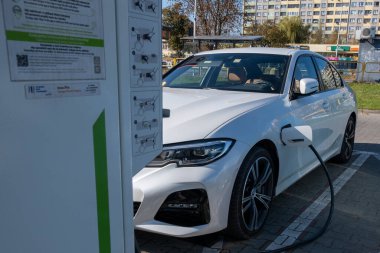 Şarj istasyonundan beyaz bir elektrikli arabayı teşvik etme süreci. Yüksek kalite fotoğraf