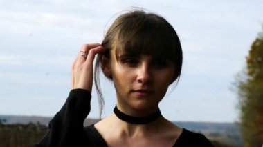 Güzel genç kız saçlarını sonbahar ormanının arka planına doğru düzeltiyor, ağır çekimde. Yüksek kaliteli FullHD görüntüler