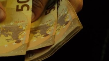 Bir adam 50 avroluk banknotları sayıyor, yakın plan, yavaşlatılmış. Yüksek kaliteli FullHD görüntüler