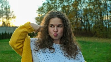 Genç bir Harana kıvırcık kızı şakağına duygusal bir parmak koydu. Yüksek kalite fotoğraf