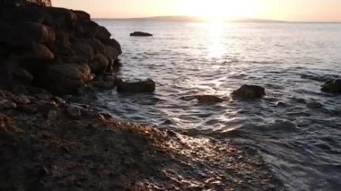 Kızıl deniz üzerinde gün doğumu, taşlar ve dalgalar, yavaş çekim videosu. Yüksek kaliteli FullHD görüntüler