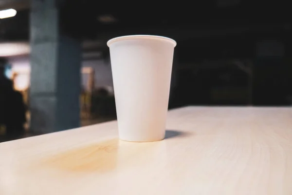White paper cup on a table in an office center. High quality photo