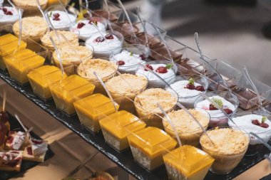 Çok renkli tatlılar siyah bir tepside servis sunuyorlar. Yüksek kalite fotoğraf