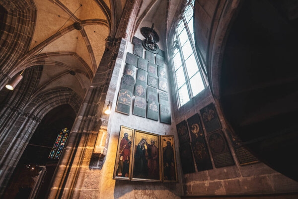 Ancient shields with knightly coats of arms and icons in the ancient Catholic Gothic cathedral in Nuremberg, Germany. High quality photo