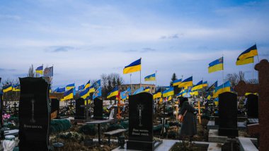 Tomb of a Ukrainian soldier who died in the war at the cemetery with Ukrainian flags, 24.02.2023. High quality photo