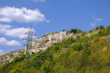 Amerika 'daki görkemli dağların arka planına karşı yüksek voltajlı elektrik direği. Yüksek kalite fotoğraf