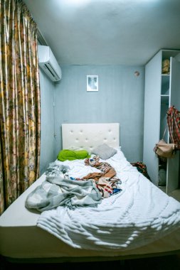 Yumuşak kumaşlarla çevrili, rahatlamak ve rahatlamak için mükemmel dağınık bir yatak odası sahnesi.