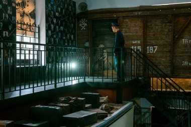 Tarihi eserler ve dramatik ışıklandırmalarla çevrili bir şahsın yer aldığı bir müze sahnesi..