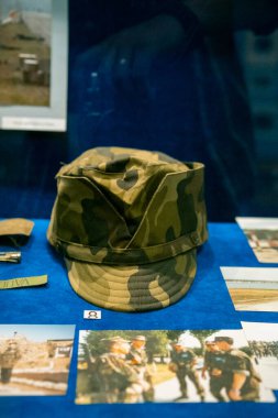 Askeri kamuflaj şapkası, askeri tarihin zenginliğini vurgulayan bir tarih müzesinde sergileniyor.