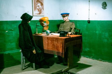 Canlı gibi görünen insan figürlerinin canlandırıcı Sovyet tarzı sorgulama sahnesinin dramatik ve yoğun bir gösterisi.