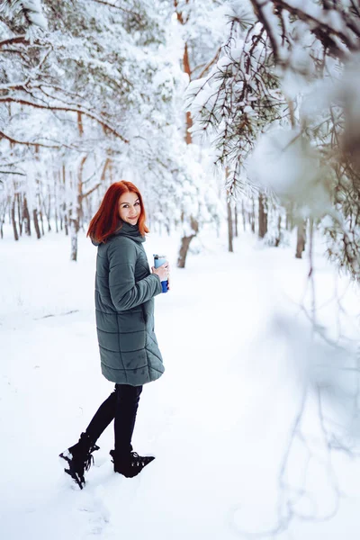 一个快乐的女孩 红头发 穿着温暖的衣服 在美丽的森林附近与雪玩耍 — 图库照片